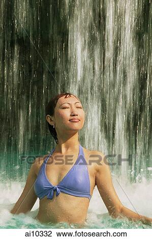 Young woman in swimming pool, water cascading on her, eyes closed View Large Photo Image Stock Image - Young woman in swimming pool, water cascading on her, eyes closed. Fotosearch