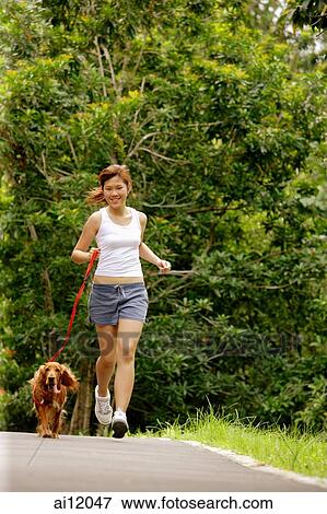 Young woman jogging with her dog View Large Photo Image Stock Photo - Young woman jogging with her dog. Fotosearch