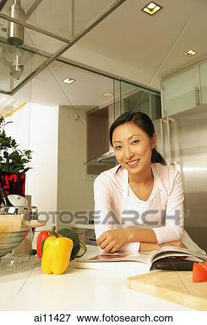 Young woman leaning on kitchen counter. View Large Photo Image Stock Photo - Young woman leaning on kitchen counter.. Fotosearch