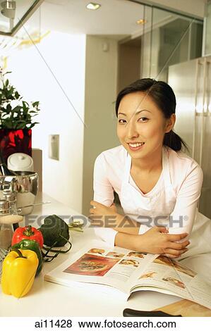 Young woman leaning on kitchen counter, looking at camera, smiling View Large Photo Image Stock Photo - Young woman leaning on kitchen counter, looking at camera, smiling. Fotosearch