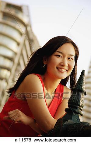 Young woman leaning on railing, looking at camera View Large Photo Image Stock Photo - Young woman leaning on railing, looking at camera. Fotosearch