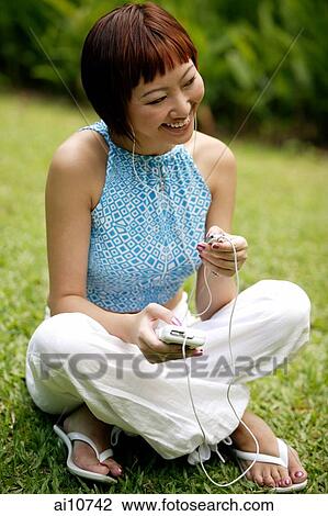Young woman listening to personal stereo View Large Photo Image Stock Image - Young woman listening to personal stereo. Fotosearch