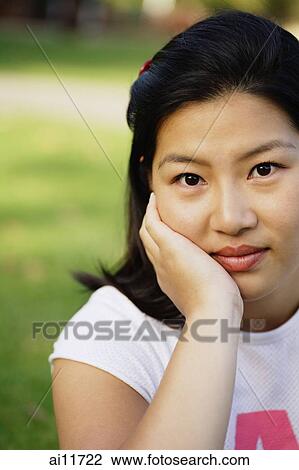 Young woman looking at camera, hand on chin, portrait View Large Photo Image Stock Image - Young woman looking at camera, hand on chin, portrait. Fotosearch