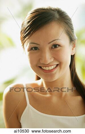 Young woman looking at camera, smiling View Large Photo Image Stock Image - Young woman looking at camera, smiling. Fotosearch