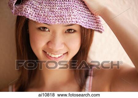 Young woman looking at camera, wearing hat View Large Photo Image Stock Photo - Young woman looking at camera, wearing hat. Fotosearch