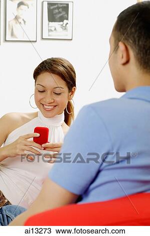 Young woman looking at ring box, young man facing her View Large Photo Image Stock Image - Young woman looking at ring box, young man facing her. Fotosearch