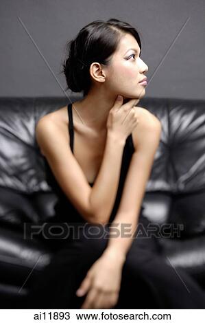 Young woman looking away, hand on chin View Large Photo Image Stock Image - Young woman looking away, hand on chin. Fotosearch