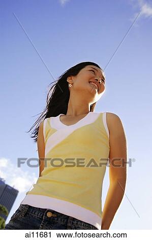 Young woman looking away, low angle view View Large Photo Image Stock Image - Young woman looking away, low angle view. Fotosearch