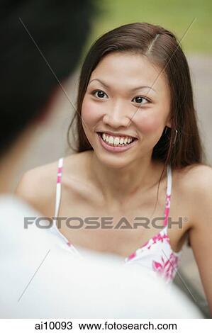 Young woman looking up, man in foreground View Large Photo Image Stock Image - Young woman looking up, man in foreground. Fotosearch