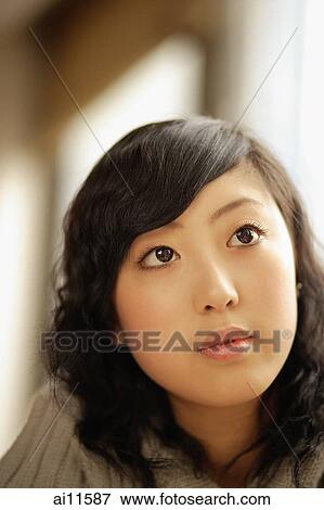 Stock Photo - Young woman, looking up, portrait. Fotosearch