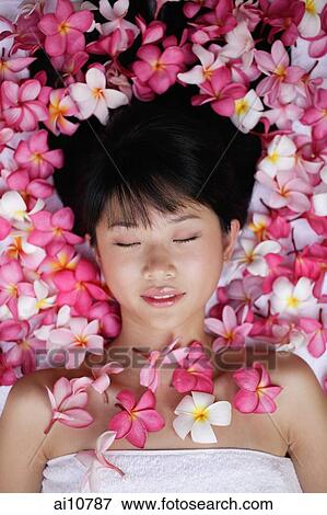 Young woman lying down amidst flowers, eyes closed View Large Photo Image Stock Photo - Young woman lying down amidst flowers, eyes closed. Fotosearch