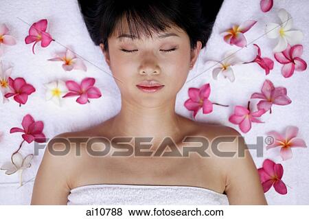 Young woman lying down amidst flowers, eyes closed View Large Photo Image Stock Photo - Young woman lying down amidst flowers, eyes closed. Fotosearch