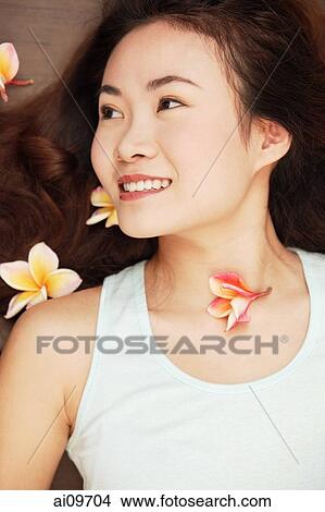 Young woman lying down, flowers in hair View Large Photo Image Picture - Young woman lying down, flowers in hair. Fotosearch