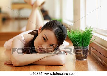 Young woman, lying down, head in arms, looking at camera View Large Photo Image Stock Photography - Young woman, lying down, head in arms, looking at camera. Fotosearch