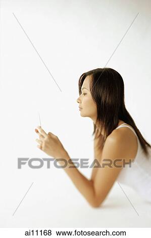 Young woman lying on floor, using mobile phone, sideview View Large Photo Image Stock Photo - Young woman lying on floor, using mobile phone, sideview. Fotosearch