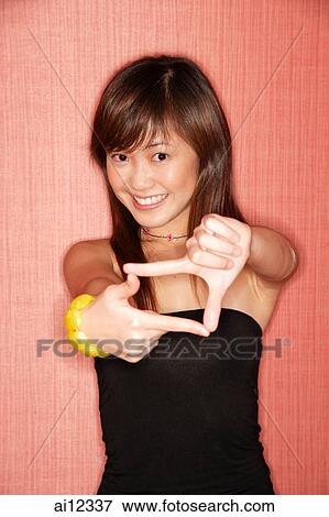 Young woman making hand sign, looking at camera View Large Photo Image Stock Photo - Young woman making hand sign, looking at camera. Fotosearch
