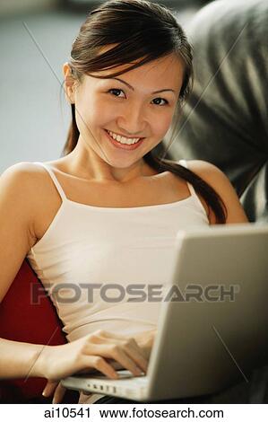 Young woman on sofa, looking at camera, smiling View Large Photo Image Stock Image - Young woman on sofa, looking at camera, smiling. Fotosearch