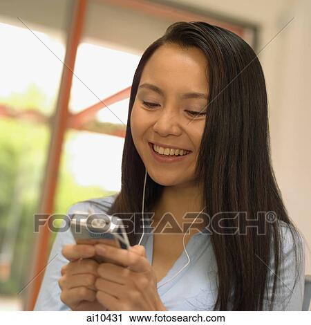 Young woman on swing, listening to personal stereo View Large Photo Image Stock Image - Young woman on swing, listening to personal stereo. Fotosearch