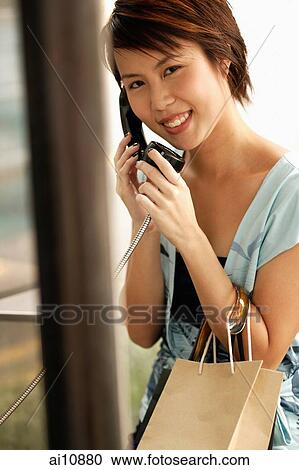 Young woman on the phone, looking at camera View Large Photo Image Stock Image - Young woman on the phone, looking at camera. Fotosearch