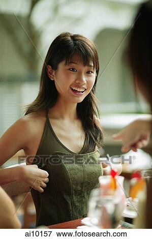Stock Photo - Young woman out with friends at cafe.. Fotosearch