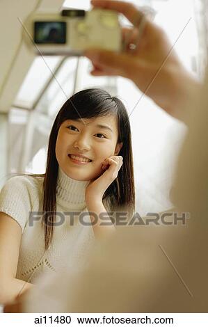 Young woman posing, friend taking picture with digital camera View Large Photo Image Stock Image - Young woman posing, friend taking picture with digital camera. Fotosearch