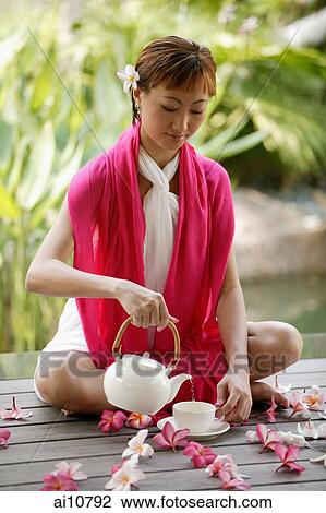 Young woman pouring tea, portrait View Large Photo Image Stock Image - Young woman pouring tea, portrait. Fotosearch