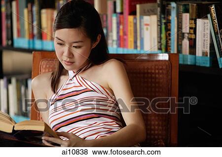 Young woman reading a book View Large Photo Image Stock Photo - Young woman reading a book. Fotosearch