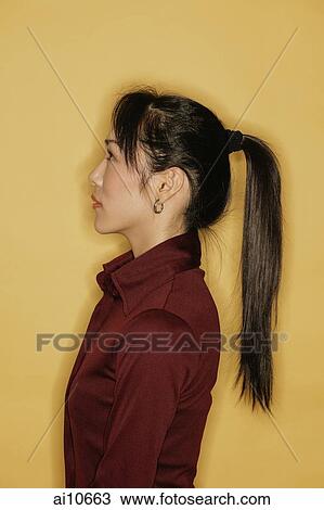 Young woman, side view, yellow background View Large Photo Image Stock Image - Young woman, side view, yellow background. Fotosearch