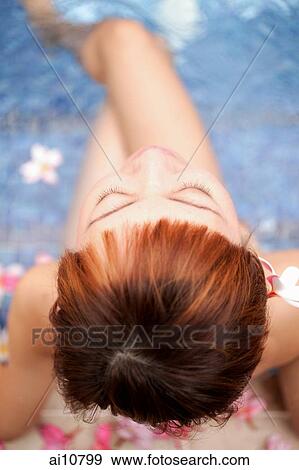 Young woman sitting at edge of pool, directly above View Large Photo Image Stock Photo - Young woman sitting at edge of pool, directly above. Fotosearch