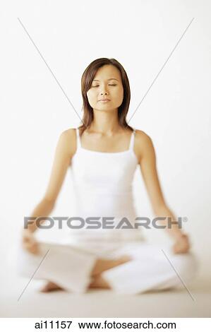 Young woman sitting in lotus position, eyes closed View Large Photo Image Stock Photo - Young woman sitting in lotus position, eyes closed. Fotosearch