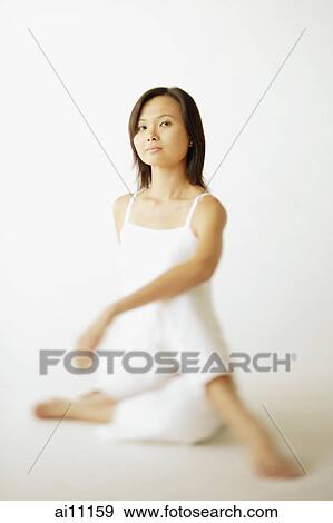 Young woman sitting on floor, looking at camera View Large Photo Image Stock Photo - Young woman sitting on floor, looking at camera. Fotosearch