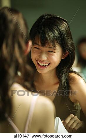 Young woman smiling, facing her friend View Large Photo Image Stock Photo - Young woman smiling, facing her friend. Fotosearch