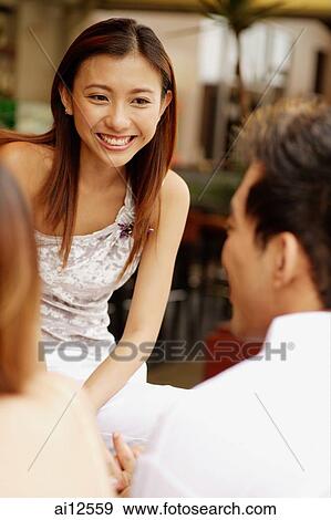 Young woman smiling, facing two other people View Large Photo Image Stock Photo - Young woman smiling, facing two other people. Fotosearch
