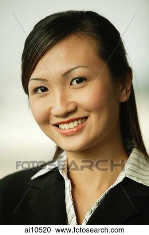 Stock Image - Young woman smiling looking at camera. Fotosearch