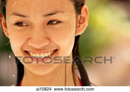 Picture - Young woman smiling, looking away. Fotosearch