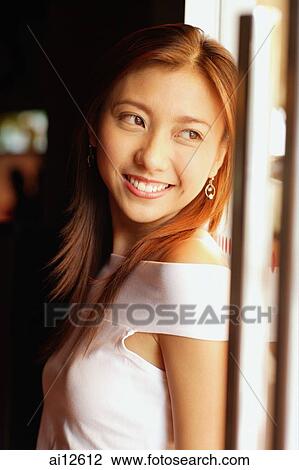 Young woman smiling, looking away, portrait View Large Photo Image Stock Image - Young woman smiling, looking away, portrait. Fotosearch