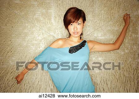 Young woman standing, arms outstretched, looking at camera View Large Photo Image Stock Photo - Young woman standing, arms outstretched, looking at camera. Fotosearch