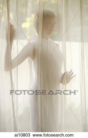Young woman standing behind curtain View Large Photo Image Stock Image - Young woman standing behind curtain. Fotosearch