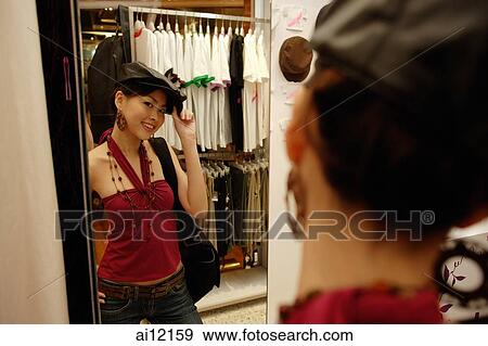 Young woman trying on beret in shop View Large Photo Image Stock Photo - Young woman trying on beret in shop. Fotosearch