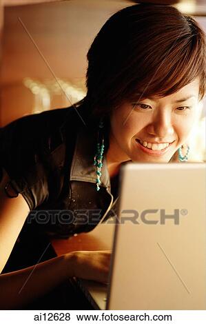 Stock Photo - Young woman using a laptop. Fotosearch