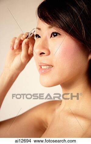 Young woman using eyebrow tweezers View Large Photo Image Picture - Young woman using eyebrow tweezers. Fotosearch