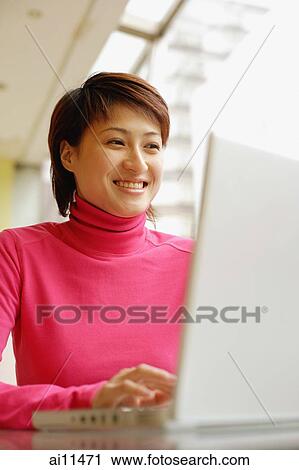 Young woman using laptop, smiling View Large Photo Image Stock Image - Young woman using laptop, smiling. Fotosearch