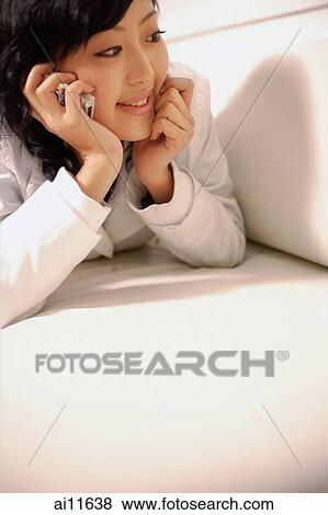 Young woman using mobile phone, hand on chin View Large Photo Image Stock Photo - Young woman using mobile phone, hand on chin. Fotosearch