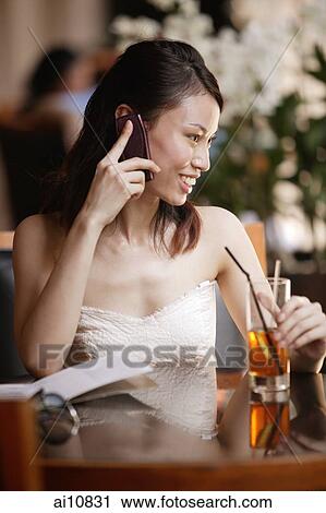 Young woman using mobile phone in a cafe View Large Photo Image Stock Image - Young woman using mobile phone in a cafe. Fotosearch