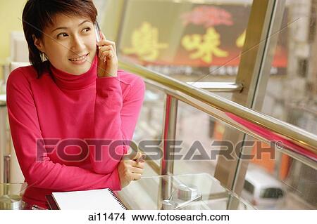 Young woman using mobile phone, looking away View Large Photo Image Picture - Young woman using mobile phone, looking away. Fotosearch
