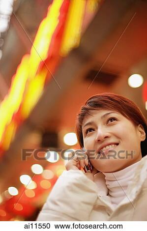 Young woman using mobile phone, looking up View Large Photo Image Stock Image - Young woman using mobile phone, looking up. Fotosearch