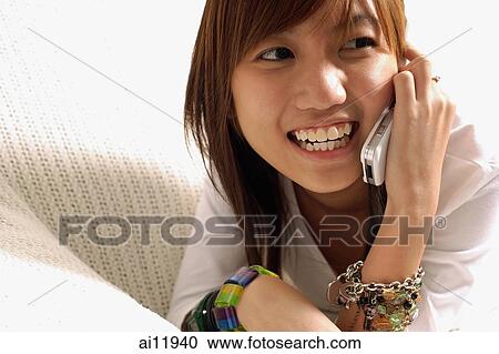 Young woman using mobile phone, looking away View Large Photo Image Stock Image - Young woman using mobile phone, looking away. Fotosearch