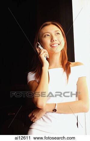 Young woman using mobile phone, looking away View Large Photo Image Stock Image - Young woman using mobile phone, looking away. Fotosearch