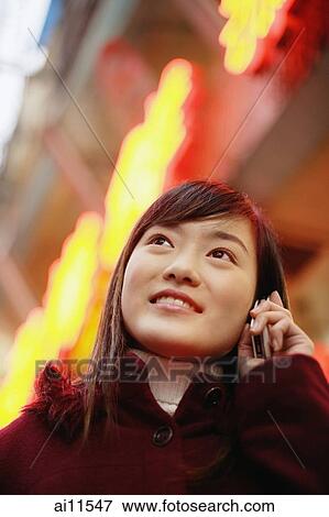 Young woman using mobile phone, looking up View Large Photo Image Stock Photo - Young woman using mobile phone, looking up. Fotosearch