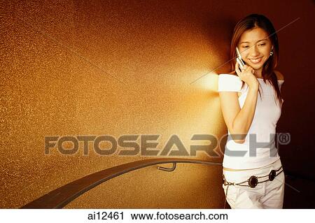 Young woman using mobile phone, smiling View Large Photo Image Stock Image - Young woman using mobile phone, smiling. Fotosearch